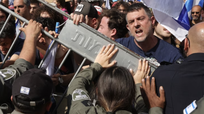 Police hold back demonstrators blocking the Ayalon Road in Tel Aviv's city center on Wednesday. (Abir Sultan/EPA-EFE/Shutterstock)