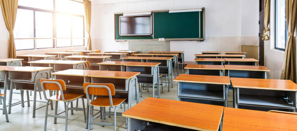 Empty modern classroom with chairs, desks and chalkboard.