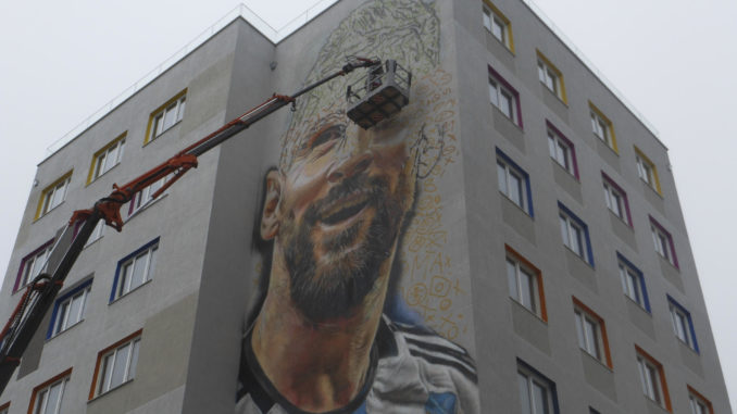 TIRANA (ALBANIA), 08/06/2023.- Un gigantesco mural de un Lionel Messi sonriente con la camiseta de Argentina, firmado por su compatriota Maximiliano Bagnasco, embellece una de las zonas más pobladas de la Tirana (Albania) y será una nueva atracción para los amantes de fútbol. La obra, la primera de un futbolista en la capital albanesa, ha despertado el interés de numerosos curiosos que se detienen a contemplar la fachada de una nueva residencia universitaria de nueve pisos para estudiantes de Medicina, situada cerca del principal hospital de Tirana. EFE/ Mimoza Dhima