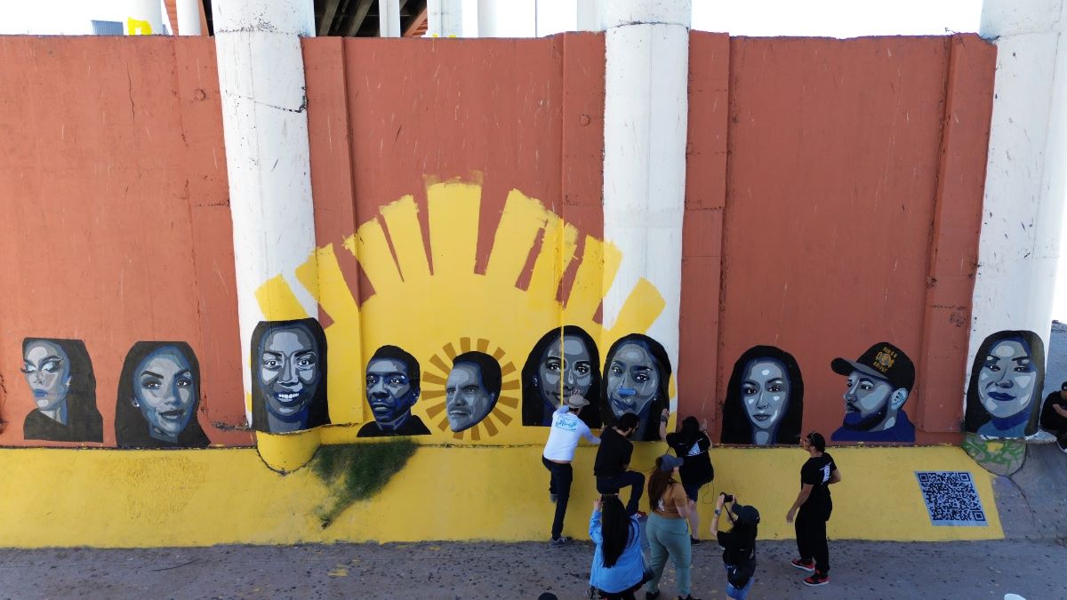 Artista pinta un mural sobre la deportación en la frontera entre México y Estados Unidos