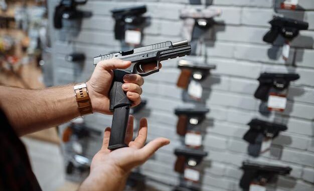 hombre-elige-nueva-pistola-escaparate-armeria_266732-23565